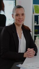 Poster - Vertical video: Portrait of woman working on business with computer at desk. Engineer using data charts for marketing strategy, planning corporate development and finance while looking at camera