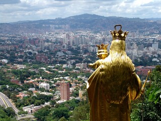 Wall Mural - Golden statue of  Virgen Maria Auxiliadora with the city background