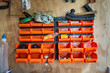 Wall hanging, tool shed, storage organiser plastic shelf rack. Orange colour on wooden wall.