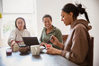© Caia Image - Happy mother and daughters eating breakfast at home