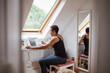 © Caia Image - Mature woman working from home at laptop below skylight