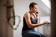© Caia Image - Mature woman talking on smart phone in home office
