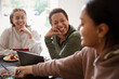 © Caia Image - Happy mother and young adult daughters talking at home