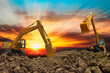 Excavator is digging in the construction site ,on a sunset background .