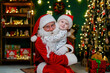 © ZaStock - Happy little boy in Santa's hat hugging with Santa Claus near Christmas tree. New Year concept