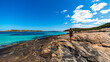 long-haired girl in black dress walks on the rocks at the edge of paradise beach in western australia, famous beaches with turquoise water and white sand in western australia, near esperance