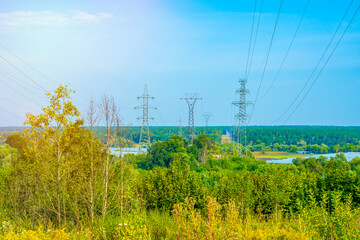 Wall Mural - Countryside electric power transmission line on the background of the forest. Three-phase power transmission and supply system in remote areas.