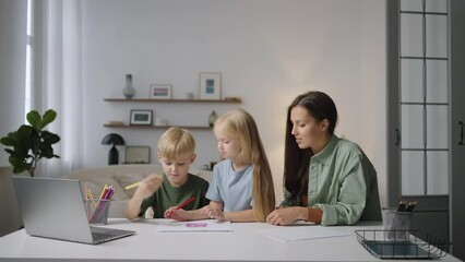 a young mother or nanny helps two blond children to complete a task while looking at a laptop. help 