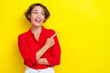 Portrait of gorgeous sweet positive woman with bob hairdo dressed red shirt directing empty space isolated on yellow color background