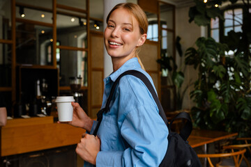 Wall Mural - Ginger white woman drinking coffee while using cellphone at cafe