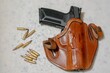 Gun in brown holster on white background