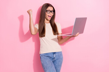 Wall Mural - Portrait of delighted cheerful lady hold use wireless netbook raise fist achievement isolated on pink color background