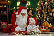 © ZaStock - Nice boy having fun with Santa Clause while lying on the floor near Christmas tree. New Year concept