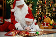 © ZaStock - Cute child drawing with Santa Clause while lying on the floor near Christmas tree. New Year concept