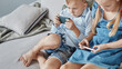 little brother and sister enthusiastically play games on their smartphones .