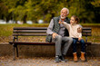 © BGStock72 - Grandfather spending time with his granddaughter on bench in park on autumn day