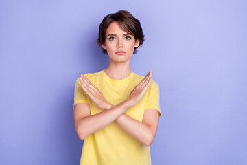 Poster - Photo of young adorable gorgeous nice woman serious wear yellow t-shirt crossed hands no stop symbol isolated on purple color background