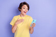 Portrait of impressed crazy lady use telephone read unexpected news isolated on purple color background
