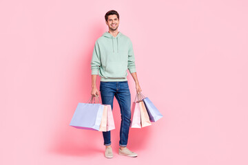 Poster - Full length photo of cheerful stylish businessman wear grey jeans outfit satisfied shopping stand space isolated on pink color background