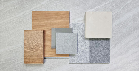 group of modern interior material samples for finishing work including oak engineering flooring, vinyl flooring tile, grey grainy stone tile, cream onyx artificial stone, grey quartzs.
