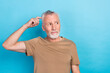 Portrait of thoughtful retired senior with gray hair beard dressed beige t-shirt look empty space isolated on blue color background
