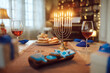 Burning candles in menorah with traditional Jewish sweet food and kosher wine on table.
