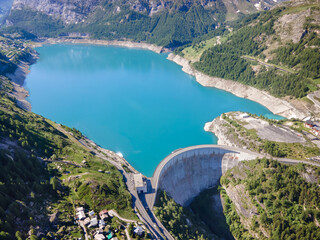 Poster - Water dam and blue reservoir lake aerial view in Alps mountains generating hydroelectricity. Low CO2 footprint, decarbonize, renewable energy, sustainable development, hydro power.