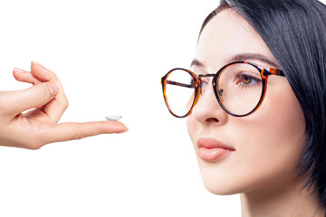 Young woman in glasses decides to wear contact lenses.