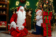 © ZaStock - Little boy building high tower from gift boxes with Santa Claus. Christmas Scenes. New Year concept