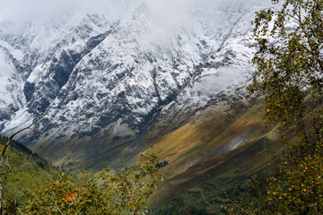 magnificent view of a long glacial valley through snow and cloud topped Pyrenees mountains