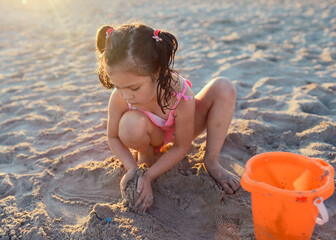 cute girl with pony tails is playing on the beach