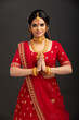 Pretty Indian young Hindu Bride against grey background.