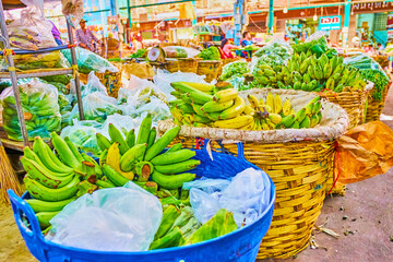 Canvas Print - Large baskets with green bananas in Wang Burapha Phirom agricultural market in Bangkok, Thailand