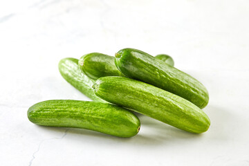 Poster - Mini cucumbers on white marble, ready to cook and eat