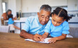 © Beaunitta Van Wyk/peopleimages.com - Homework, child and grandfather helping with education, learning and studying in a notebook in their house. Senior man teaching and giving help to a girl writing in a book for school work in home