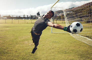 Poster - Soccer, sports and goalkeeper training on a field for a professional competition. Young and strong athlete with energy and motivation catching a football during a game or exercise on a sport ground