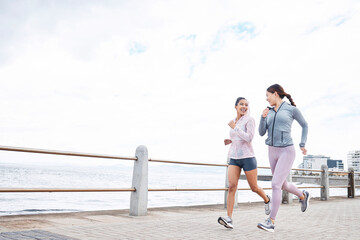 Canvas Print - Running, friends and runner women by the sea in nature for fitness, wellness and exercise. Smile of people in health cardio training, sports and strong workout with happiness from athlete motivation