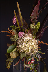 Wall Mural - Floral beautiful artistic still life, design and interior details. Artificial pink hydrangea in a vase on a black dark background in an old rustic vintage style with a copy space