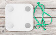 © SashaMagic - White floor scales and measuring tape. The process of losing weight. Getting rid of excess weight. Melt off
