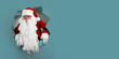 © ZaStock - Emotianal Santa Claus peeking out of a paper hole. christmas advertisement concept. Space for text