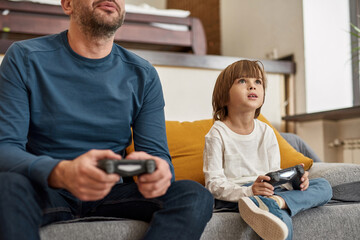 Wall Mural - Little boy and cropped father playing video game