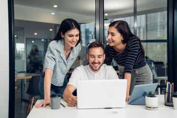 Wall Mural - Happy diverse friends watching funny video, laughing at joke, using laptop and having fun together, brainstorm together at meeting