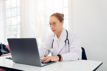 Woman doctor in uniform greeting patients online on laptop during on line meeting.	