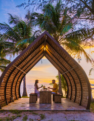 Wall Mural - Romantic dinner on the beach with Thai food during sunset on the Island of Koh Mak Thailand. Couple men and women having romantic dinner on the beach