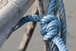 Dettaglio di una corda azzurra annodata e legata ad una struttura di legno sulla spiaggia di Pellestrina in una giornata invernale
