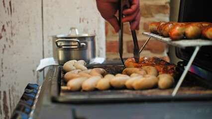 Sticker - Hand turning the tasty sausages on the grill to cook