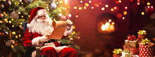 Santa Claus Sitting At His Room At Home Near Christmas Tree And Reading Christmas Letter Or Wish List