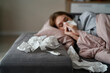 © gpointstudio - Caucasian young woman with high temperature and flu lying down on sofa