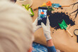 © Jelena Stanojkovic - Beautiful mature woman gardener taking picture of green plants and flowers with smartphone. Home garden workplace home among plants in the home garden, agriculture.