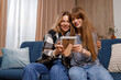 © Andrii  - Happy family mom and daughter sitting on the sofa and looking at frame photo in home